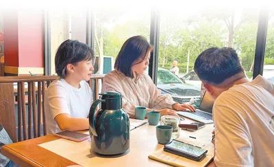 張文宇（左二）和客戶分析季度數(shù)據(jù)情況。梁之磊攝