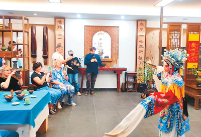 外國游客在黃山屯蒙學舍體驗徽劇文化。  　　舒少菲攝