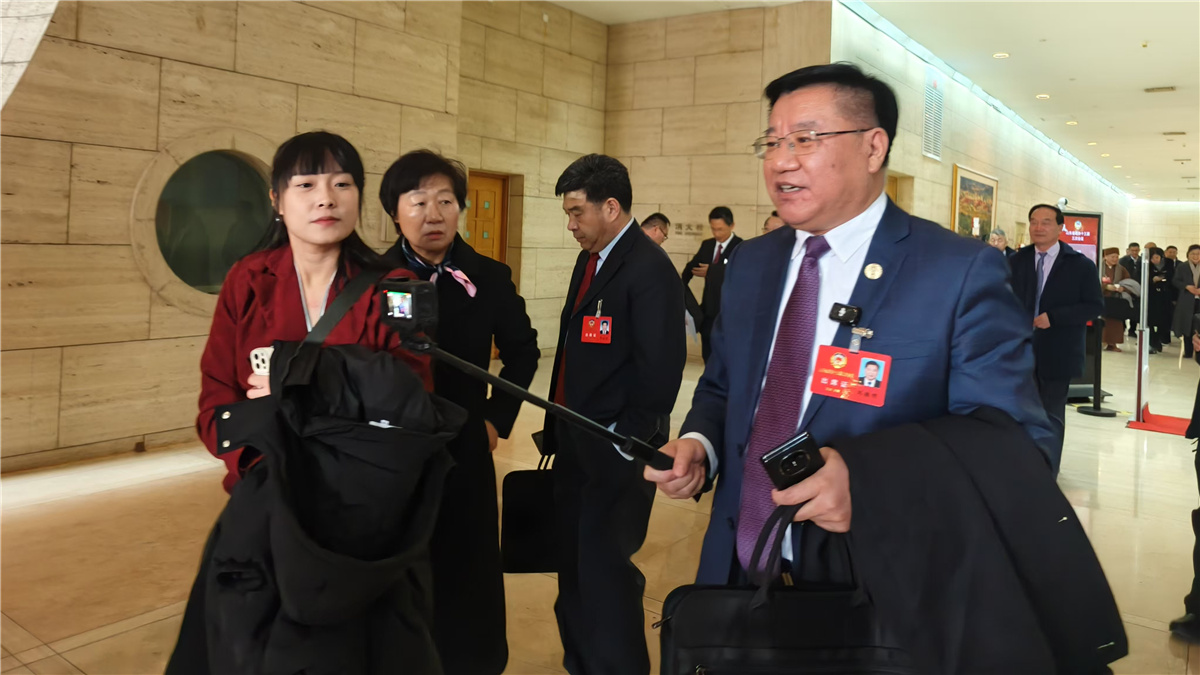 1月19日，山東省政協(xié)十三屆三次會(huì)議開幕，一位委員走出會(huì)場(chǎng)，邊走邊接受采訪。人民網(wǎng)記者宋翠攝