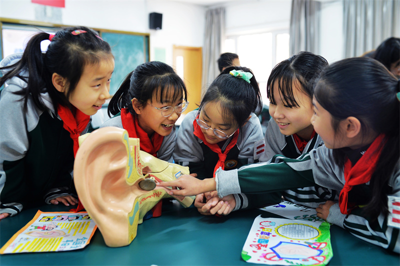 在山東青島市北實(shí)驗(yàn)小學(xué)、無棣四路小學(xué)開展的“全國愛耳日”活動上，學(xué)生們在觀看耳朵構(gòu)造模型。