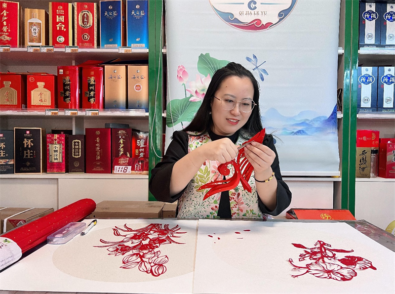 圖為沈文瑩在創(chuàng)作剪紙作品