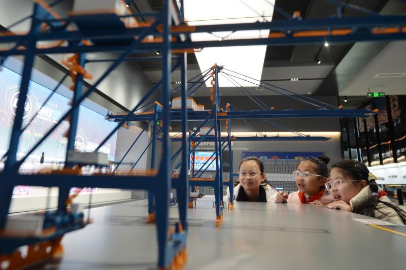 學(xué)生們?cè)谟^看岸邊集裝箱起重機(jī)模型。