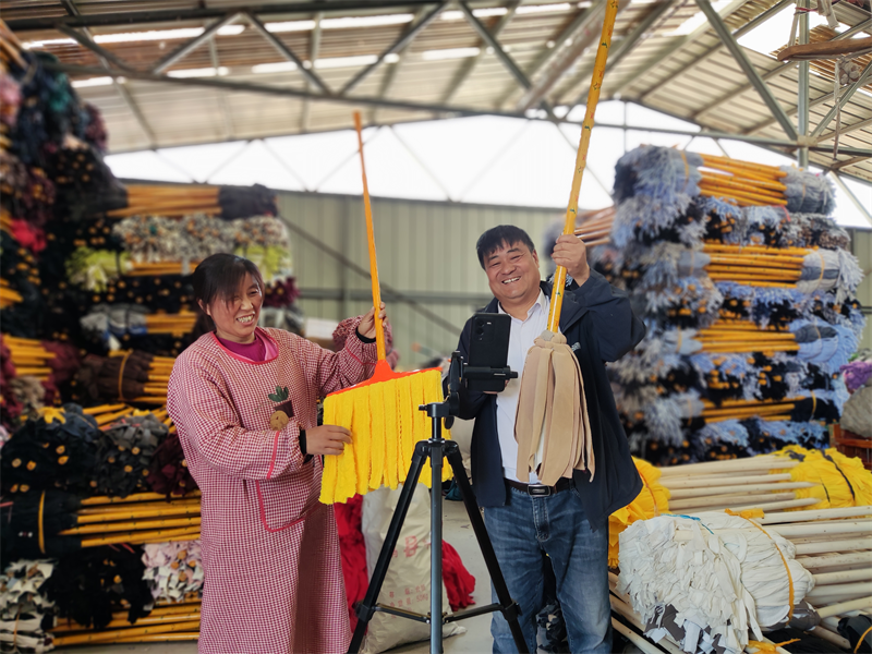 圖為李宗花(左)在通過線上直播銷售拖把