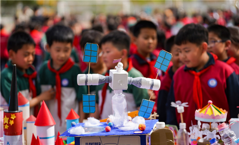 2025年4月16日，山東省樂陵市市中街道阜平小學(xué)科技勞動周現(xiàn)場，小學(xué)生在觀看航天科技裝備模型。