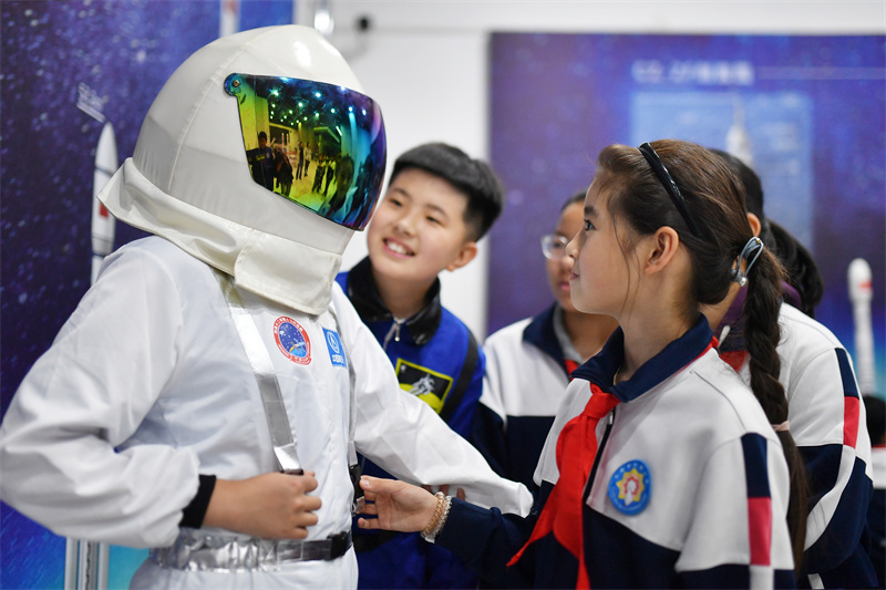 2025年4月23日，在山東省青島市市北區(qū)開平路小學(xué)開展的“中國航天日”科普活動上，學(xué)生們穿戴宇航服感受航天的魅力。