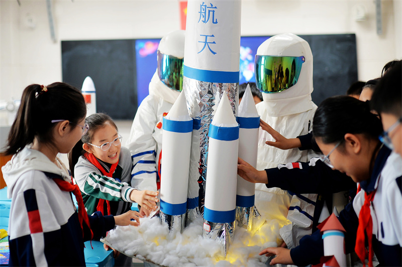 2025年4月24日，在山東省青島市市北區(qū)洛陽路第二小學(xué)開展的“中國航天日”科普活動上，學(xué)生們在擺放自制的運載火箭模型。
