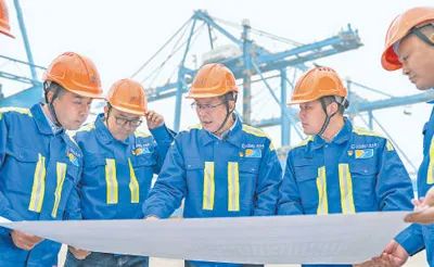 張連鋼(中)與團(tuán)隊(duì)成員討論自動(dòng)化碼頭設(shè)計(jì)方案。資料圖片