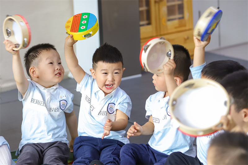 2025年5月14日，在山東省青島市李滄區(qū)職工子女愛(ài)心托育中心，老師帶領(lǐng)小朋友做游戲。張鷹 攝 