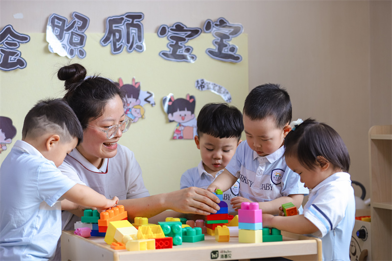 2025年5月14日，在山東省青島市李滄區(qū)職工子女愛(ài)心托育中心，小朋友在老師的精心照護(hù)下搭積木。張鷹 攝