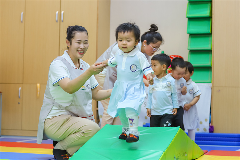 2025年5月14日，在山東省青島市李滄區(qū)職工子女愛(ài)心托育中心，小朋友在老師的精心照護(hù)下做運(yùn)動(dòng)。張鷹 攝 