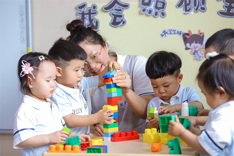 2025年5月14日，在山東省青島市李滄區(qū)職工子女愛(ài)心托育中心，小朋友在老師的陪伴下搭積木。張鷹 攝 