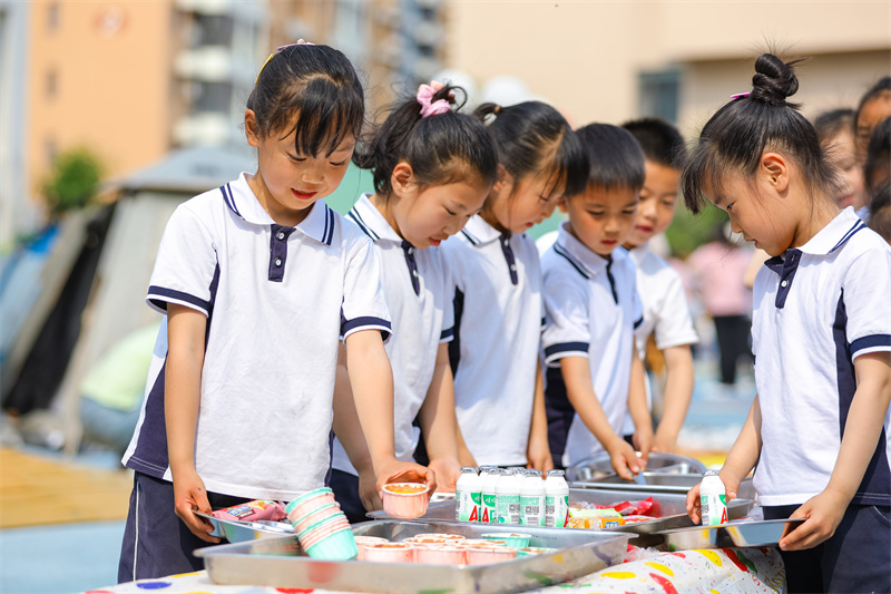 2025年5月26日，小朋友在山東省青島市李滄區(qū)青山路幼兒園開展迎“六一”主題活動中選取美食。張鷹 攝