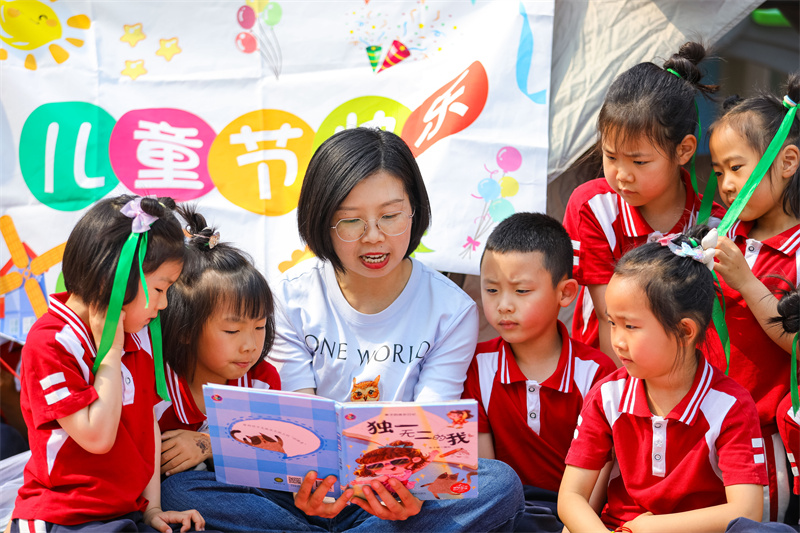 2025年5月26日，在山東省青島市李滄區(qū)青山路幼兒園開展迎“六一”主題活動中，家長為小朋友分享繪本故事。張鷹 攝