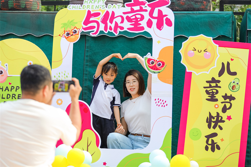 2025年5月26日，在山東省青島市李滄區(qū)青山路幼兒園開展迎“六一”主題活動中，小朋友和家長一起拍照打卡。張鷹 攝