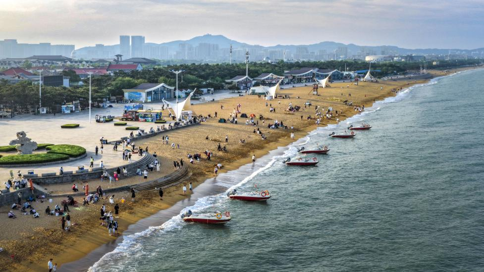 海濱沙灘上人潮涌動(dòng)，游船逐浪，把熱鬧揉進(jìn)海風(fēng)里。單英攝