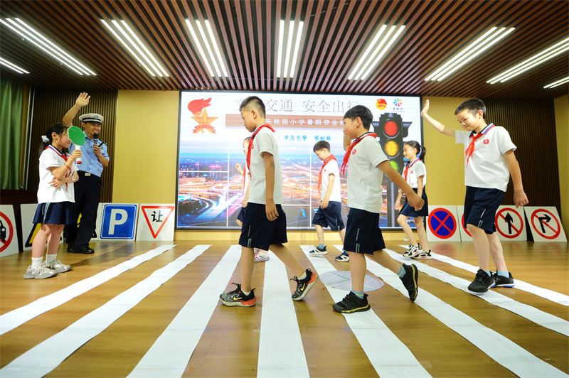 交警在指導(dǎo)學(xué)生正確通過人行橫道。王海濱攝