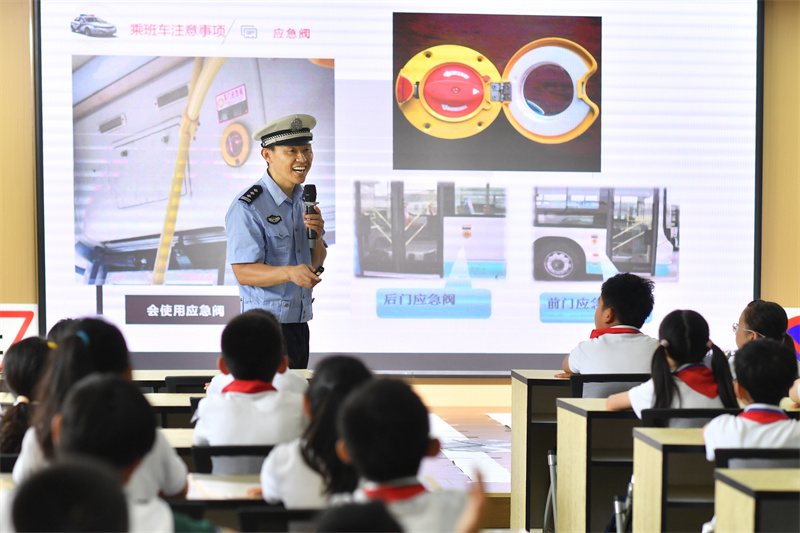 交警在講解乘坐班車注意事項。王海濱攝