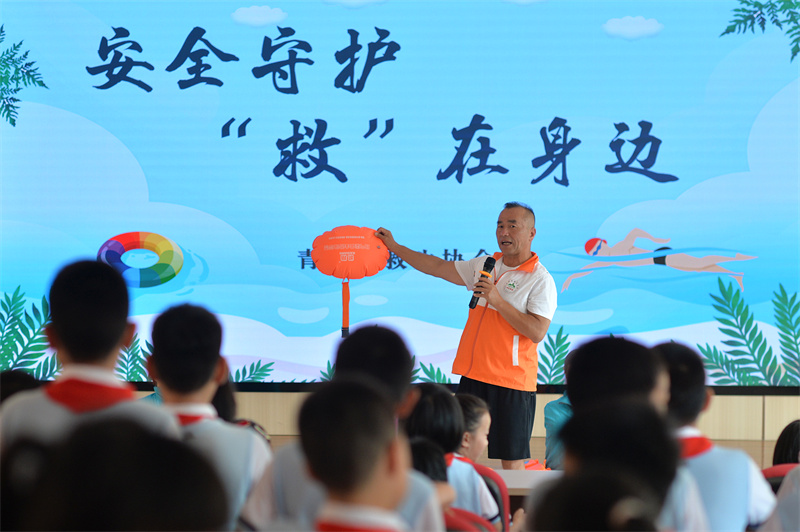 救生協(xié)會志愿者在講解游泳漂包的作用。王海濱攝