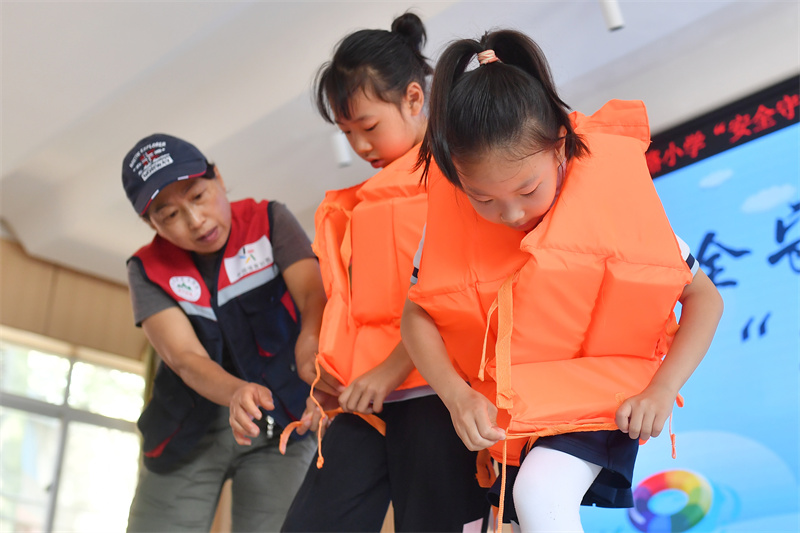 救生協(xié)會志愿者兩名學(xué)生在體驗正確穿戴救生衣。王海濱攝