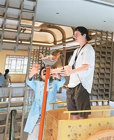 外國(guó)友人在尼山魯源村“鳴和鸞”互動(dòng)裝置體驗(yàn)傳統(tǒng)駕車技藝及禮儀。