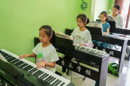 2025年7月22日，在山東省樂陵市市中街道春之聲培訓(xùn)中心，孩子們?cè)诰毩?xí)電子琴。