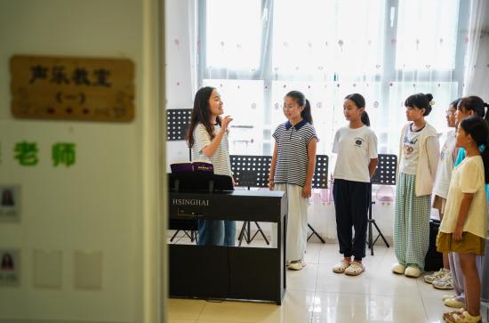 2025年7月22日，在山東省樂陵市市中街道春之聲培訓(xùn)中心，孩子們?cè)谝魳防蠋煹膸ьI(lǐng)下練習(xí)聲樂。