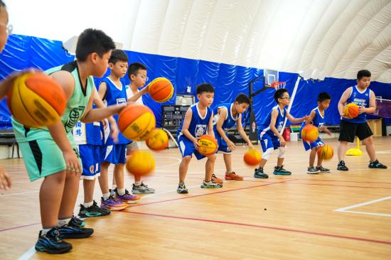 2025年7月22日，在山東省樂陵市經(jīng)濟(jì)開發(fā)區(qū)青少年活動(dòng)中心，孩子們?cè)诰毩?xí)籃球基本功。