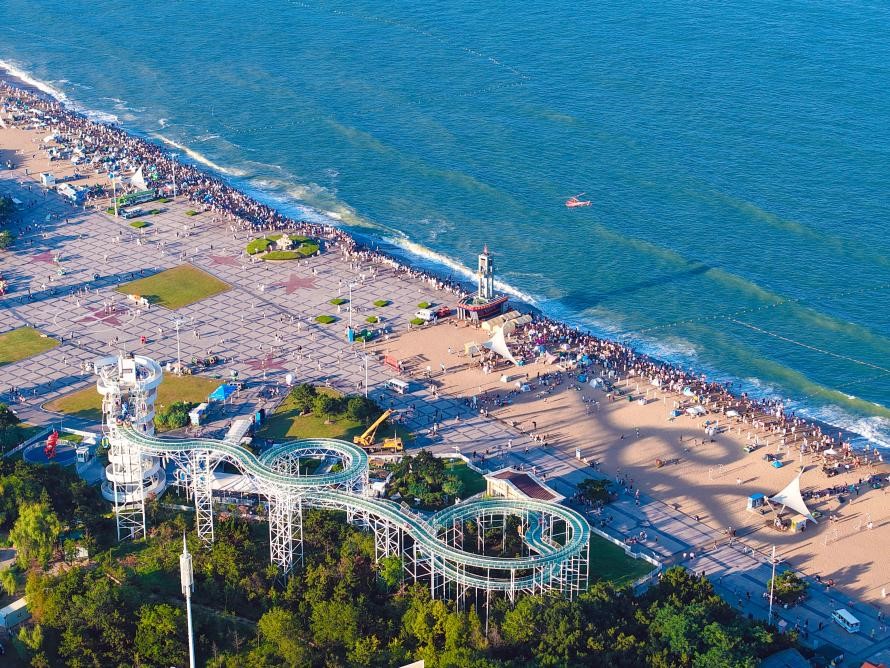 人們或在沙灘愜意相聚，沐浴夏日暖融陽光；或進行空中漂流，換個視角飽覽海景。宋年升 攝