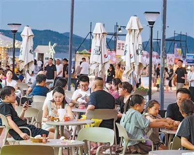 青島西海岸新區(qū)金沙灘，游客在品嘗美食。劉元波攝