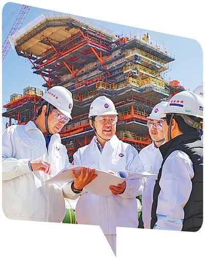 李華軍（左二）在與工作人員討論技術方案。劉??蒞攝