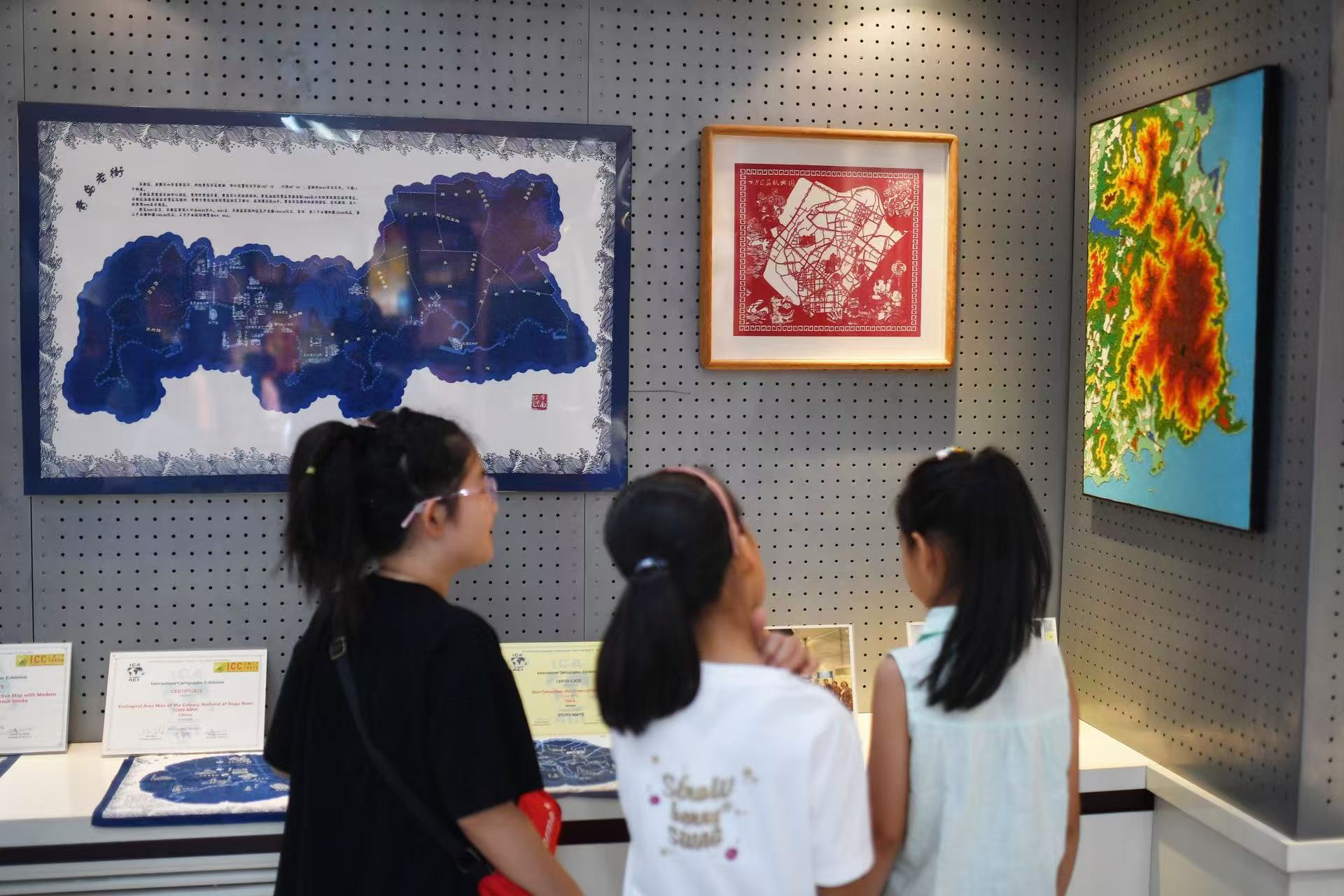 2025年8月9日，在山東省青島市勘察測(cè)繪研究院地圖文化展廳，嘉定路小學(xué)的學(xué)生在參觀青島老街地圖展。