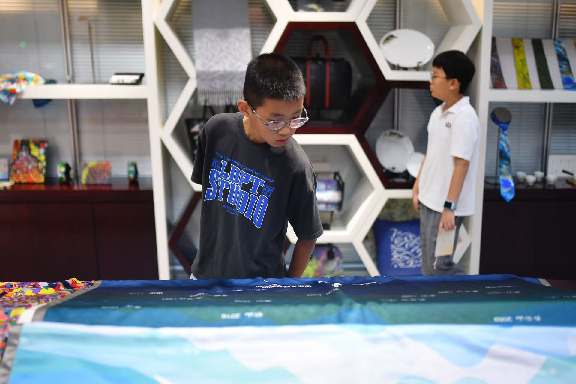 2025年8月9日，在山東省青島市勘察測(cè)繪研究院地圖文化展廳，嘉定路小學(xué)的學(xué)生在參觀創(chuàng)意地圖展。