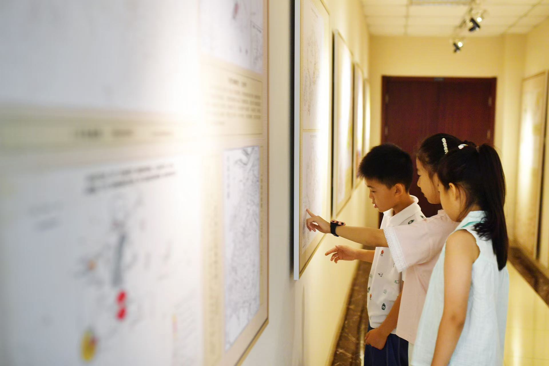 2025年8月9日，在山東省青島市勘察測(cè)繪研究院地圖文化展廳，嘉定路小學(xué)的學(xué)生在參觀歷史地圖展。