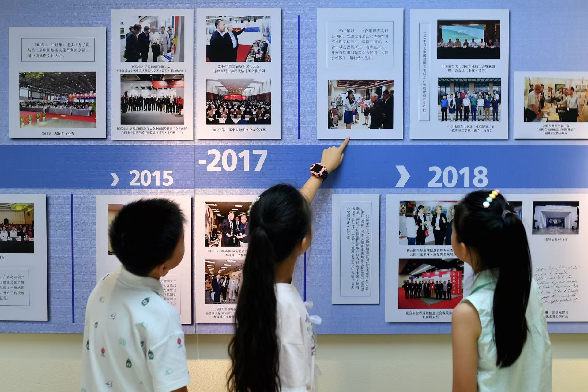 2025年8月9日，在山東省青島市勘察測(cè)繪研究院地圖文化展廳，嘉定路小學(xué)的學(xué)生在參觀歷屆地圖文化節(jié)圖片展覽。