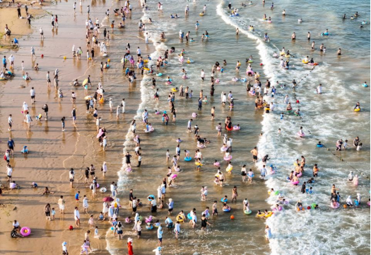 沙灘之上，人群比肩接踵。有人逐浪嬉戲，有人靜臥休憩，處處皆是享受生活的美好模樣。郭寶安攝
