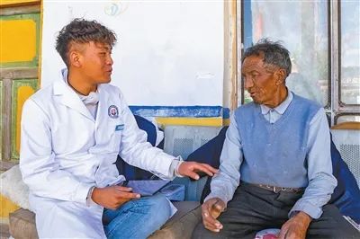 村醫(yī)索朗丹增(左)為村民進(jìn)行健康檢查。本報記者 徐馭堯攝