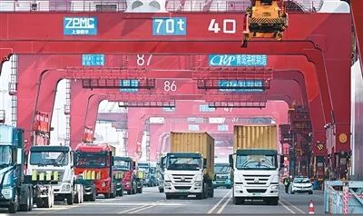 青島市上合示范區(qū)與青島港互聯(lián)互通，打造了“前港后站、一體運(yùn)作”海鐵聯(lián)運(yùn)服務(wù)模式。圖為貨車在山東港口青島港運(yùn)送集裝箱。新華社記者 李紫恒攝