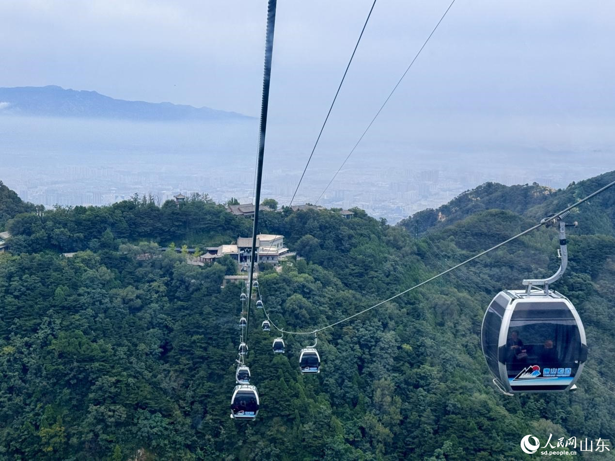 游客乘著纜車穿梭，云海峰巒盡收眼底。人民網(wǎng) 鄭昕橋攝