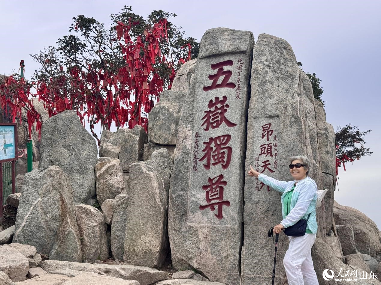    游客在泰山標志性景觀“五岳獨尊”石刻處駐足留影。人民網(wǎng) 鄭昕橋攝