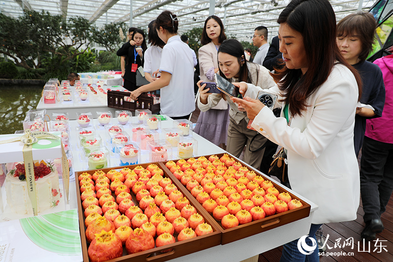 與會嘉賓品嘗、拍攝石榴相關(guān)產(chǎn)品。人民網(wǎng)記者 劉祺攝