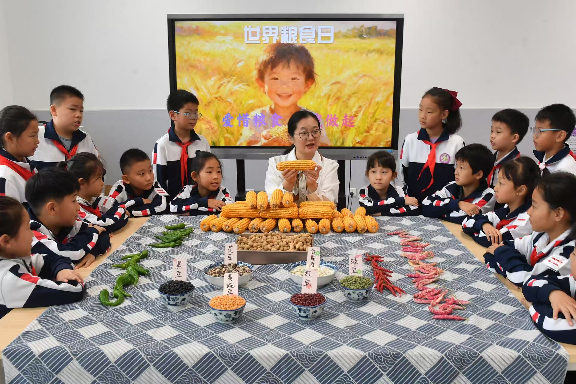 10月15日，在山東省青島市市北區(qū)杭州路小學(xué)開(kāi)展的“愛(ài)惜糧食 從我做起”主題活動(dòng)上，老師帶領(lǐng)學(xué)生辨識(shí)糧食。