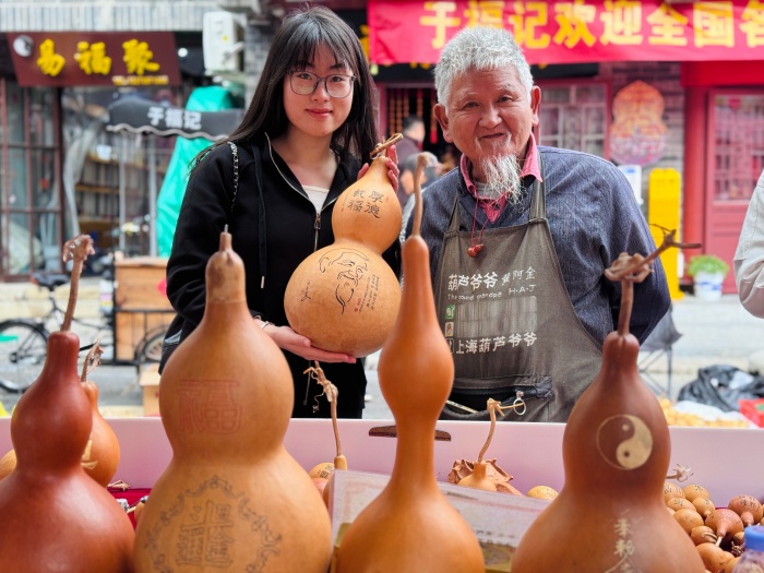 前來參展的葫蘆愛好者與手工藝人合影留念。人民網(wǎng) 鄭昕橋攝