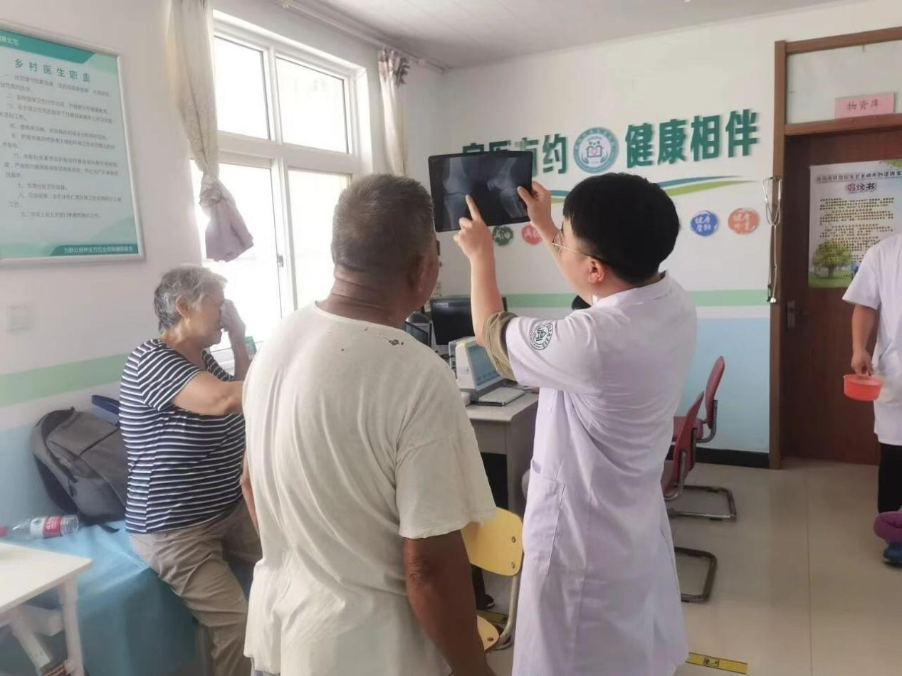 李春林耐心向老人解讀骨骼影像。受訪者供圖