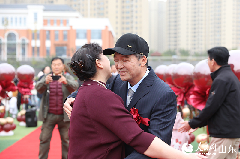在濟南市高新區(qū)金谷小學“重溫芳華 共期金婚”活動現(xiàn)場，一對金婚老人深情相擁，重現(xiàn)數(shù)十年前的美好瞬間，定格了歷久彌堅的幸福。人民網(wǎng)記者 劉祺攝