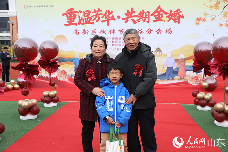 一對老人攜孫子在現(xiàn)場打卡合影。他們歷經(jīng)歲月沉淀的燦爛笑容，生動詮釋了“執(zhí)子之手，與子偕老”的動人畫面。人民網(wǎng)記者 劉祺攝