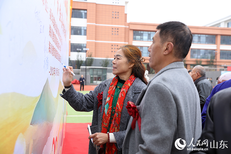 一對金婚夫婦在簽名墻上鄭重簽下自己的名字，以跨越半個世紀的筆觸，許下永恒的承諾。人民網(wǎng)記者 劉祺攝