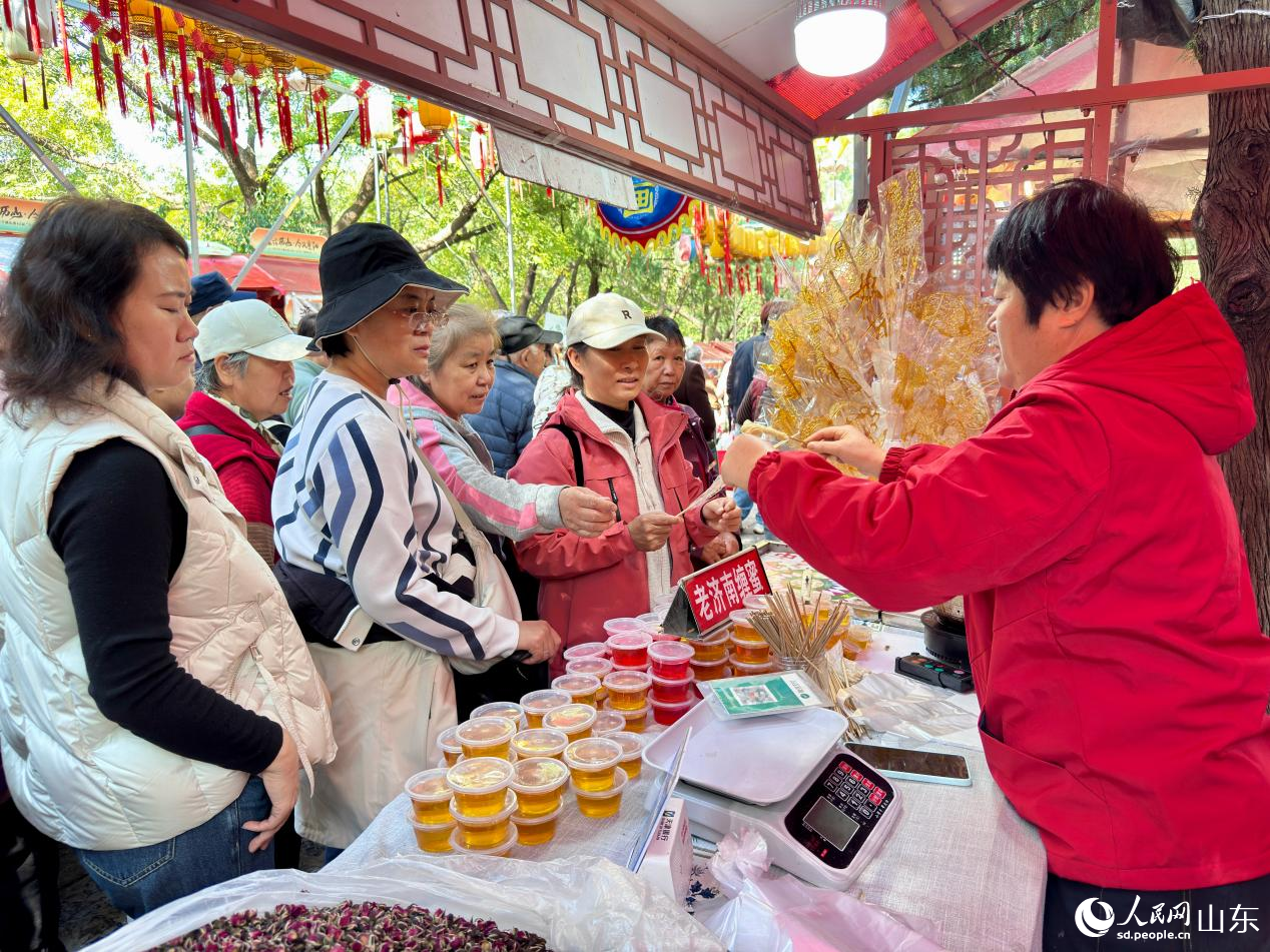 游客爭相體驗、采購老濟南纏蜜。人民網(wǎng) 鄭昕橋攝