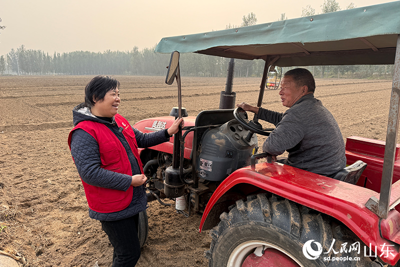 杜立芝和機(jī)播手交流播種注意事項。人民網(wǎng)記者 劉祺攝