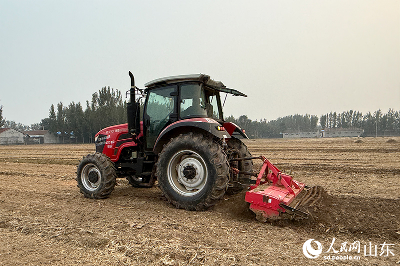 農(nóng)機(jī)手李玉華開著拖拉機(jī)馳騁在田野里。人民網(wǎng)記者 劉祺攝