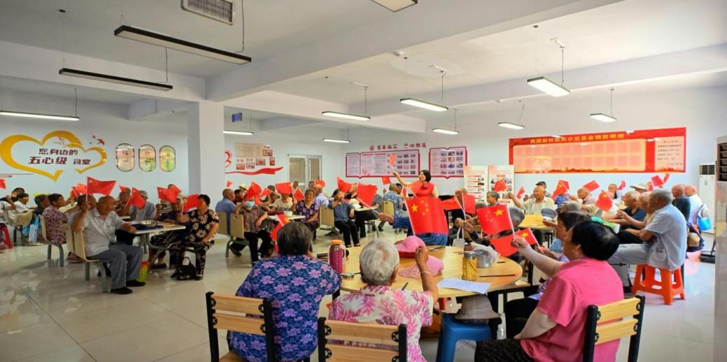 7月1日，桃園新村黨委領(lǐng)辦暖心食堂項(xiàng)目，開餐前教老人唱紅歌、做手勢操。